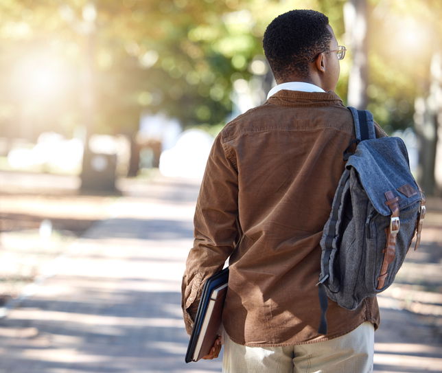 Students, School, Black man, walking or backpack on campus, park nature or garden for college, university or school studying development. Student, gen z and person with learning books, education bag or growth mindset