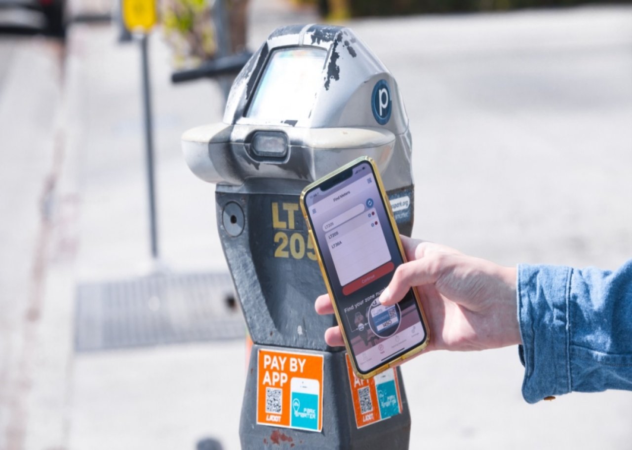 How encrypted QR Codes work A person uses their smartphone to scan a QR code on a parking meter.