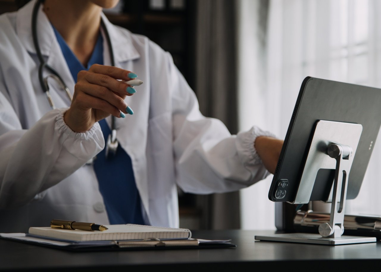 What's being done to boost security? Young physician in white coat working on computer.